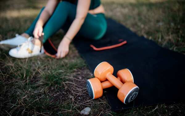 Personne adulte faisant des exercices doux sur un tapis dans un espace lumineux